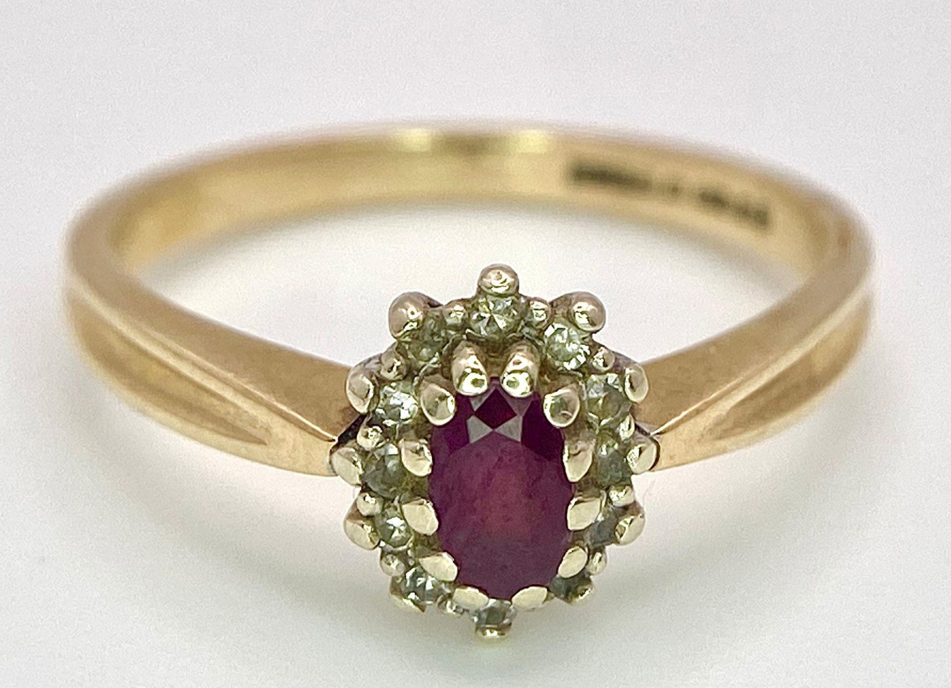 A Vintage 9K Yellow Gold Diamond and Ruby Ring. Central oval diamond with diamond surround. Size