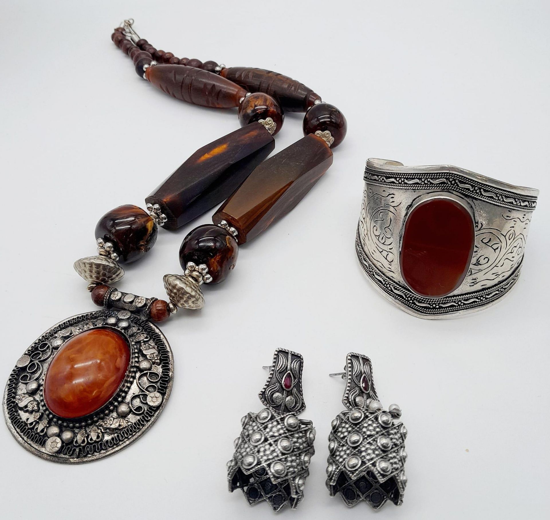 A Wonderful Trio of: Carnelian cuff bracelet, 800 German silver earrings and Berber amber resin
