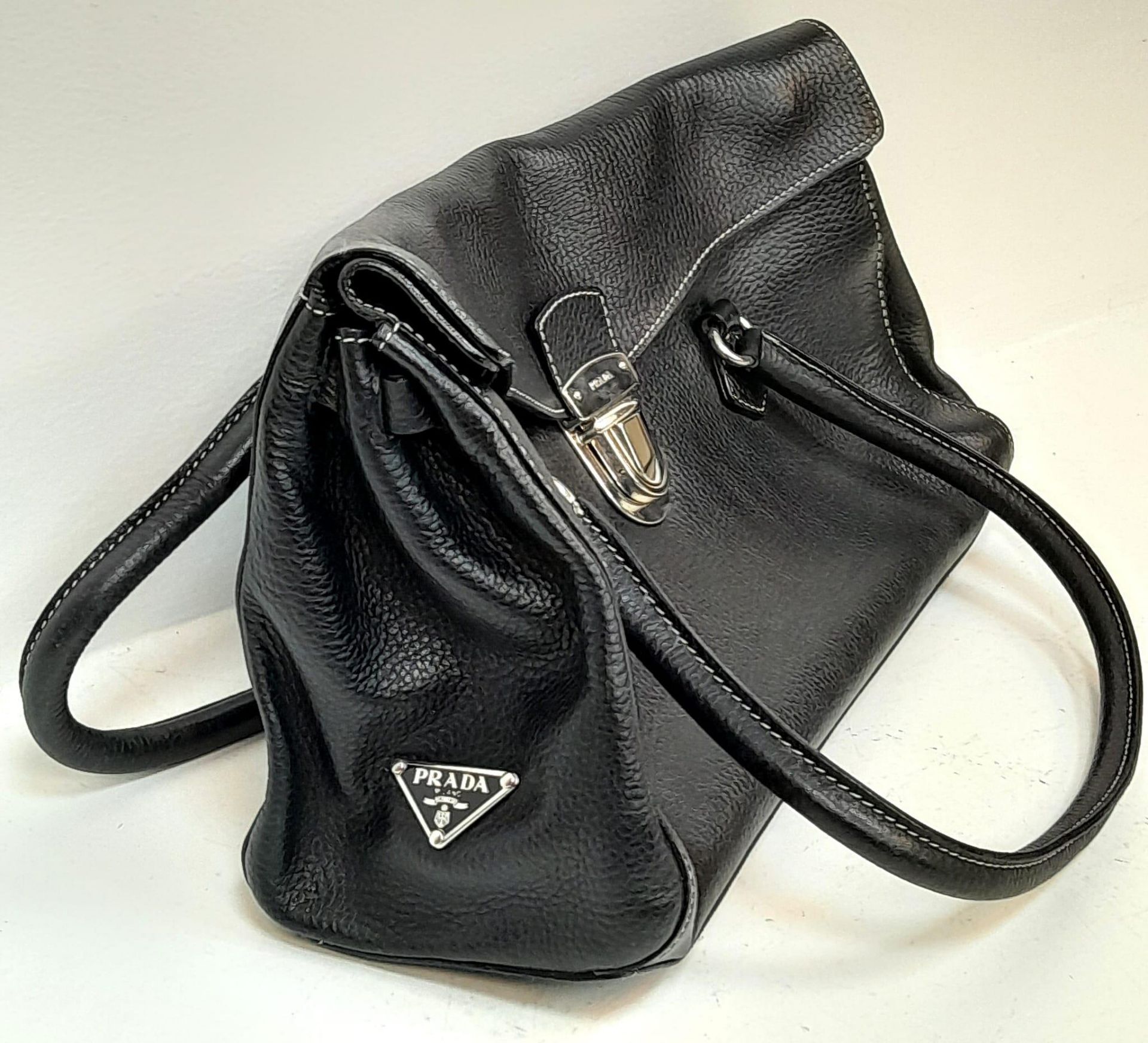 A Prada Black Shoulder Bag. Leather exterior with silver-toned hardware, two rolled leather - Bild 2 aus 7