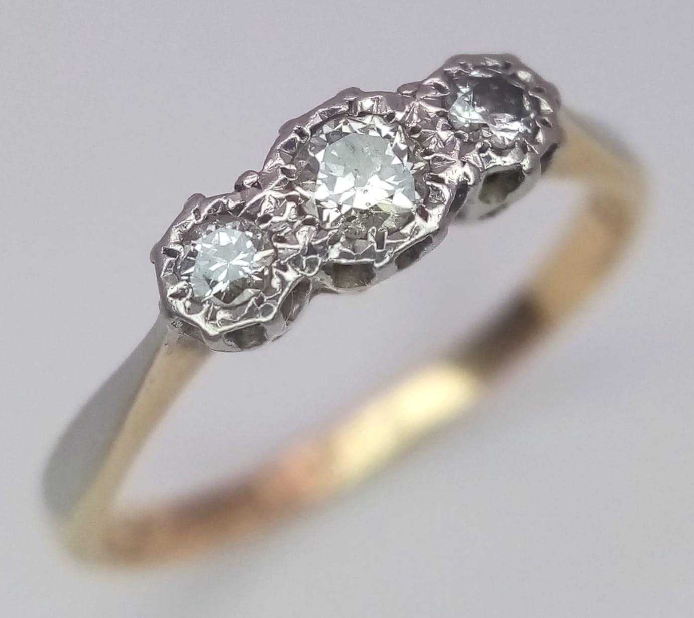An 18 K yellow gold and platinum ring with a trilogy of round cut diamonds, size: L, weight: 1.9 g.