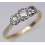 An 18 K yellow gold and platinum ring with a trilogy of round cut diamonds, size: L, weight: 1.9 g.