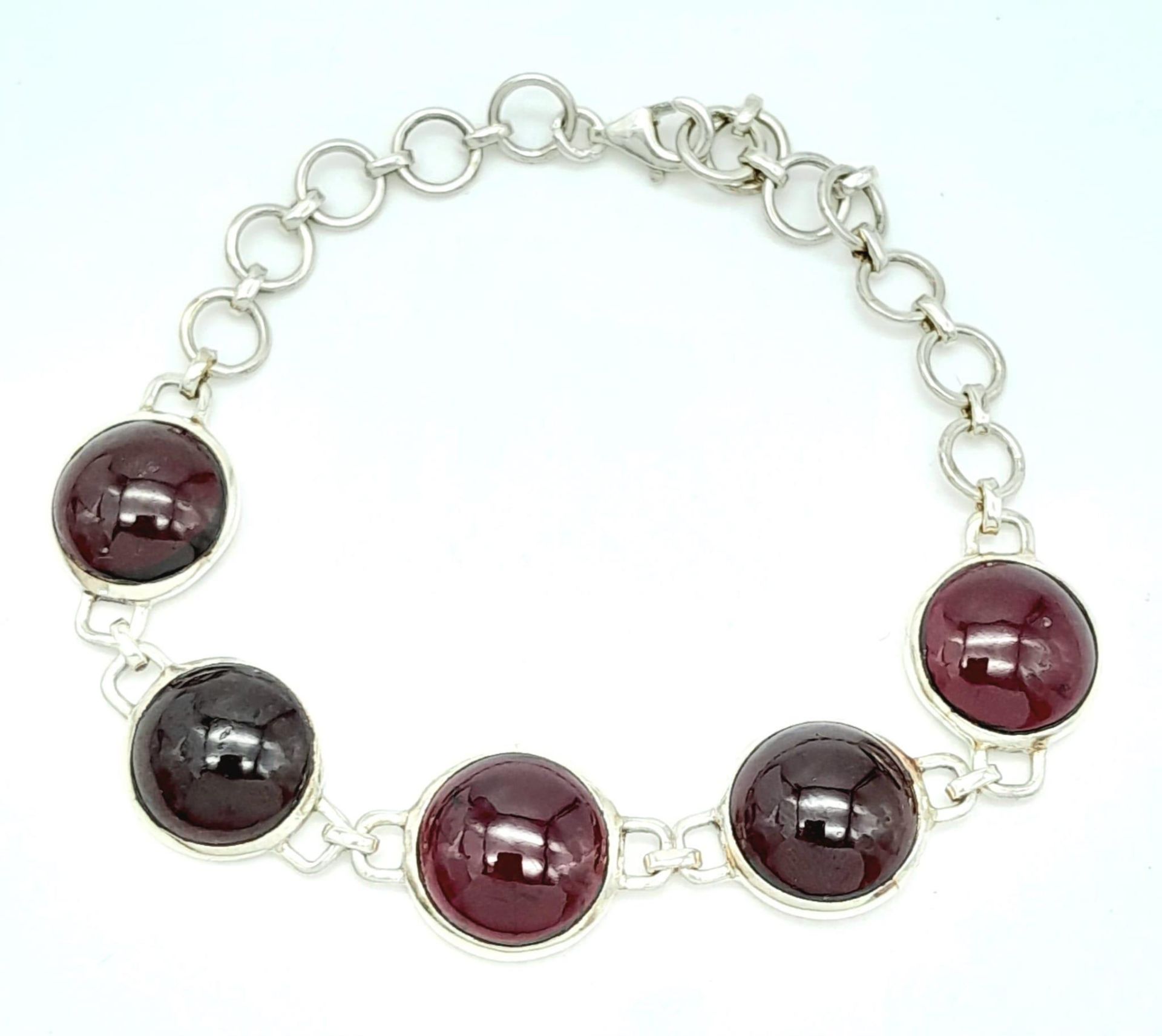 A Sterling Silver Red Stone Cabochon Set Bracelet. 19cm Length. 1.3cm Width. Gross Weight 12.75