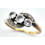 AN ANTIQUE 18K GOLD CROSSOVER STYLE RING WITH A TRILOGY OF DIAMONDS SET IN PLATINUM . 3.6gms size