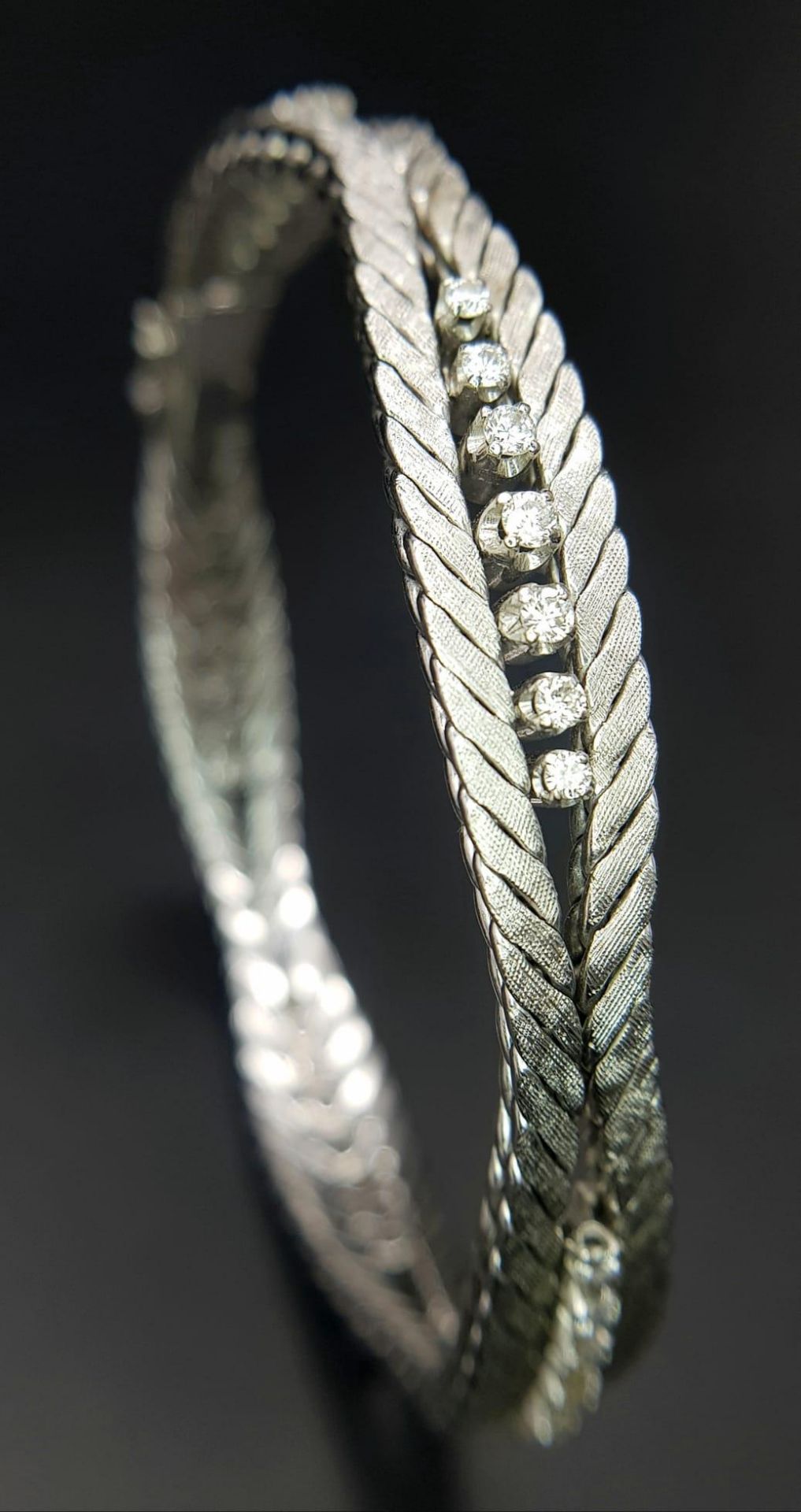 A Head-Turning 18K White Gold and Diamond Bracelet. Five waves of double-ended graduating