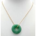 A green jade, donut shaped pendant with a 9 K yellow gold chain, in a presentation box. Total