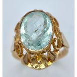 An 18K Rose Gold Aquamarine Ring. 6ct central aquamarine gemstone on a raised scroll foundation.