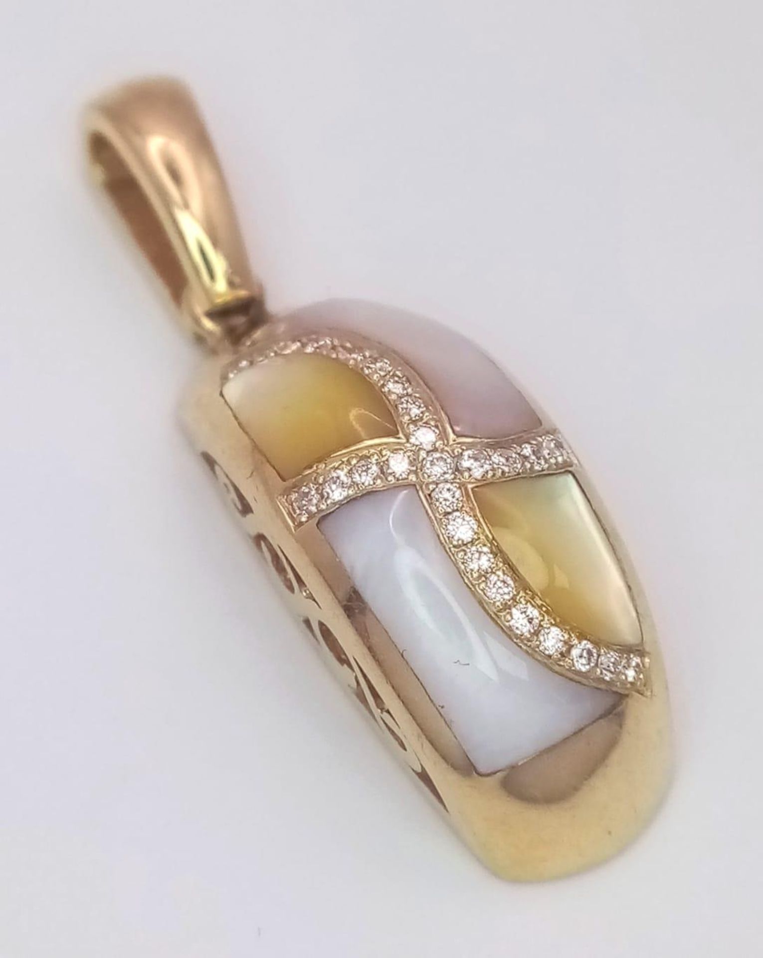 A 14 K yellow gold pendant with yellow and white Mother of pearl and diamonds arranged in a curvy