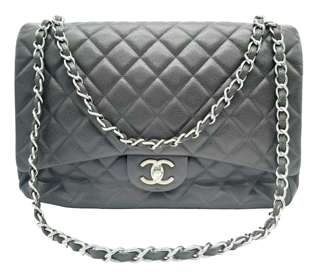 A Chanel Jumbo Double Flap Maxi Bag. Dark grey quilted caviar leather exterior with a large slip