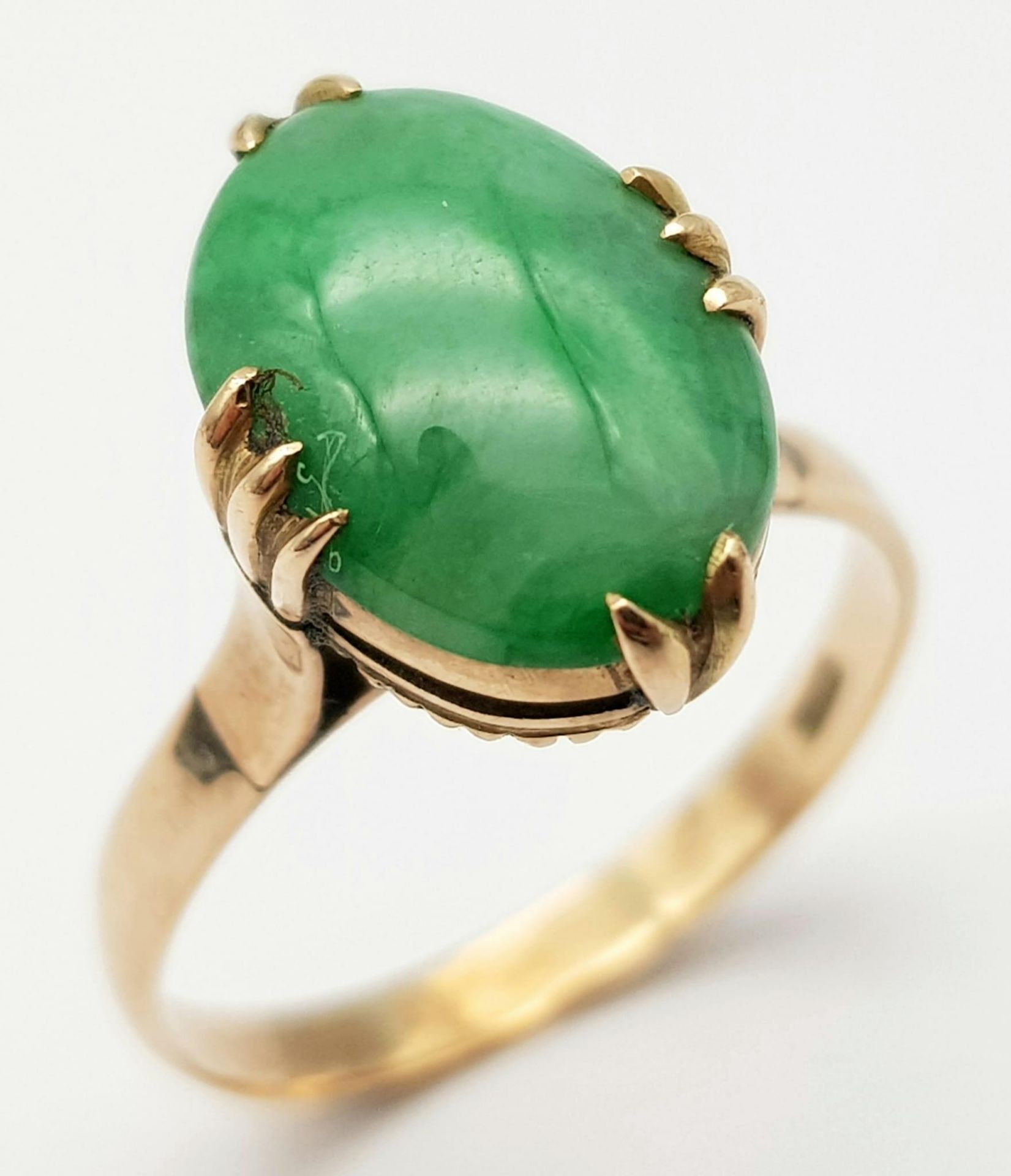 A Vintage 18K Yellow Gold Jade Ring. Oval cut jade cabochon on a four claw setting. Size R. 3.45g