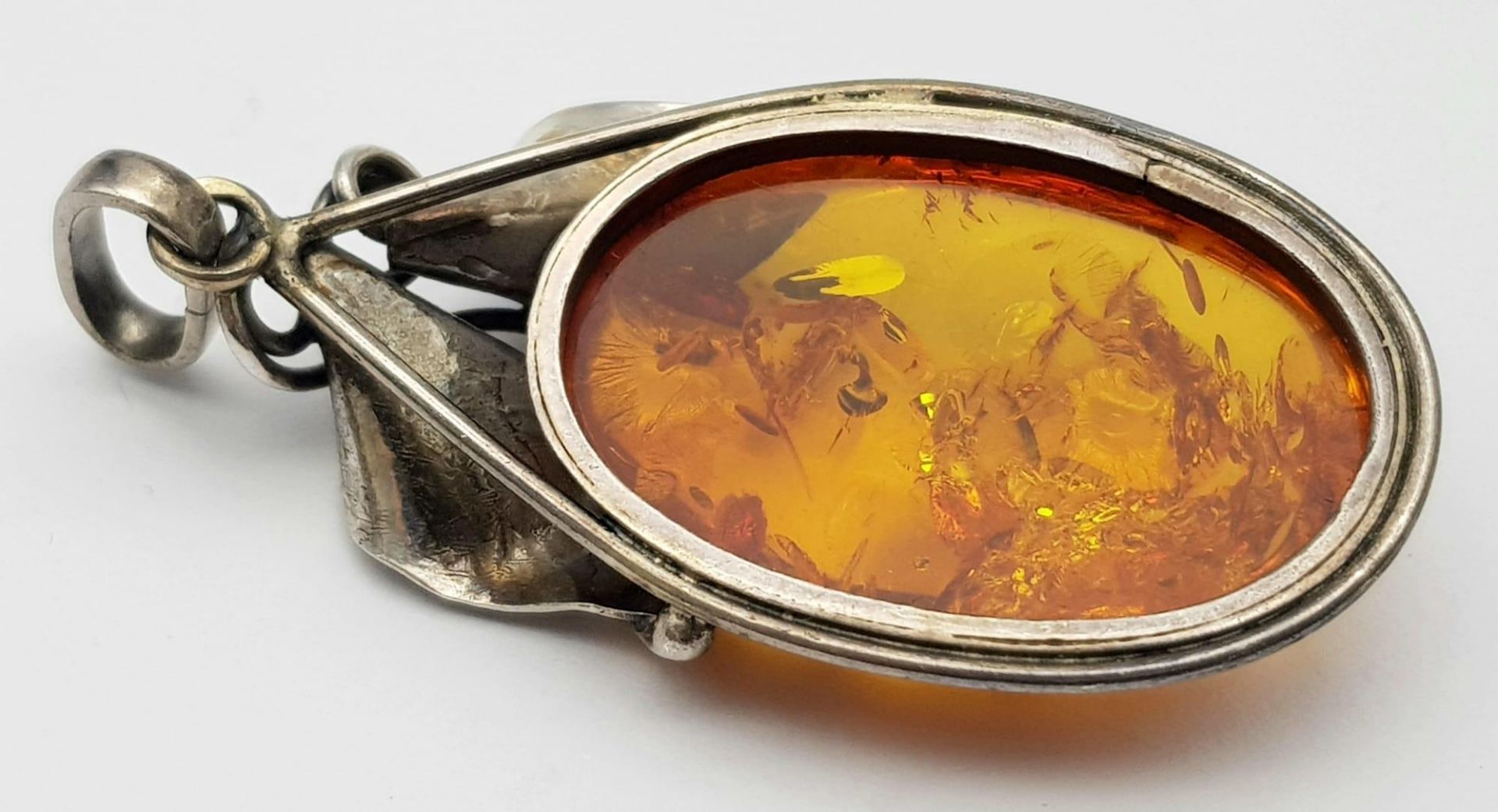 A Vintage 925 Silver and Amber Brooch. A rich amber cabochon amongst silver leaves. 6cm. 11.5g total - Image 2 of 4