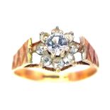 A 9K Yellow Gold Diamond Floral Ring. 0.25ct brilliant round cut central diamond with a diamond