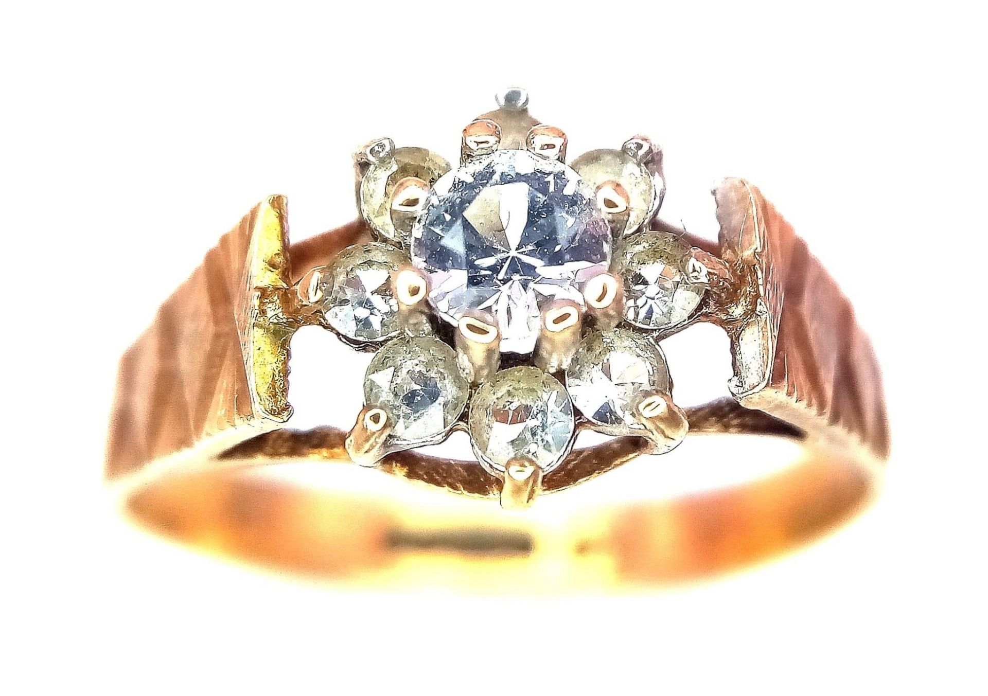 A 9K Yellow Gold Diamond Floral Ring. 0.25ct brilliant round cut central diamond with a diamond