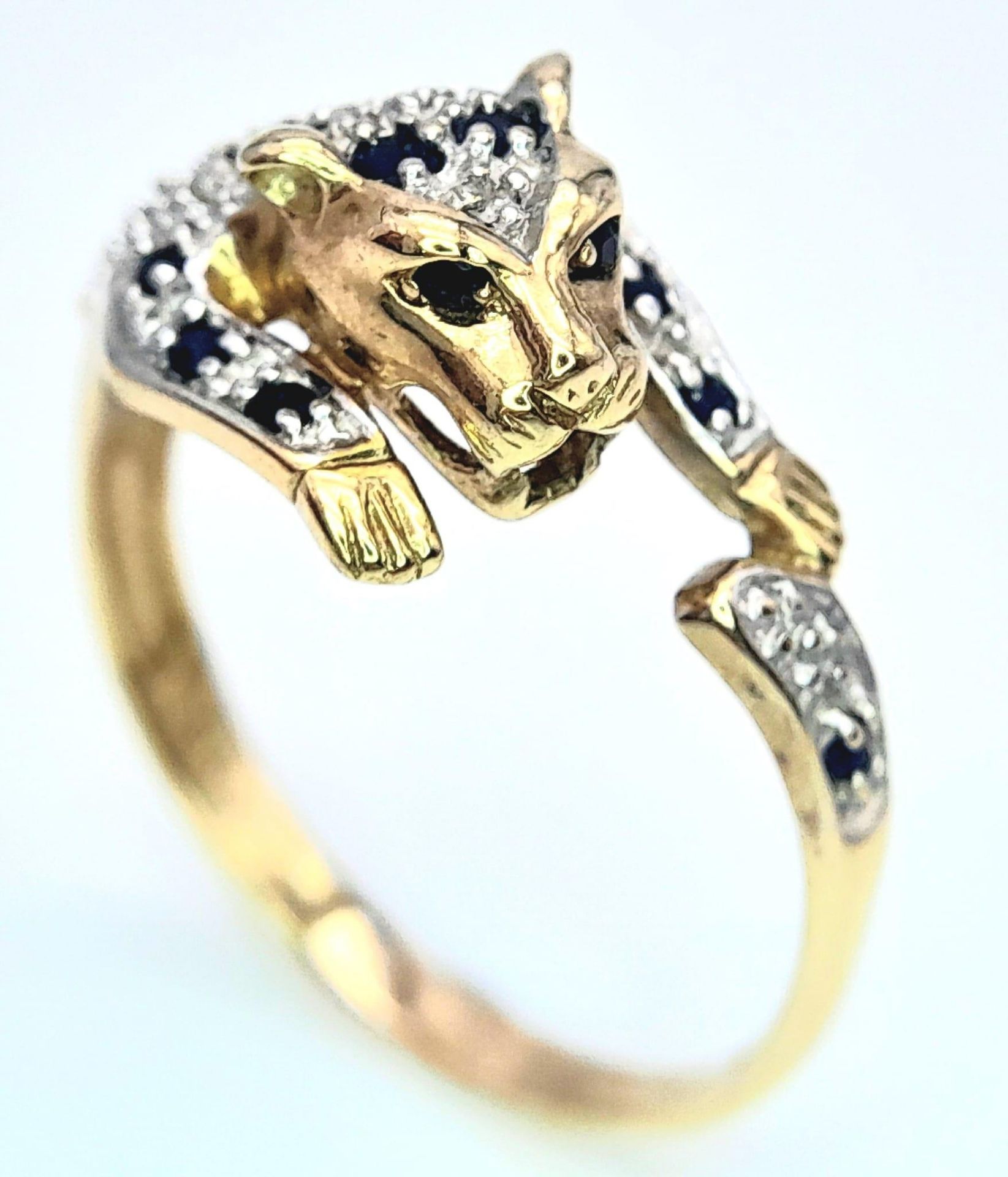 A 9K YELLOW GOLD DIAMOND & SAPPHIRE SET PANTHER RING. 3.2G. SIZE U