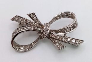 An Art Deco Style Platinum and Diamond Brooch. 1.2ctw of encrusted diamonds in a bow form. 4cm. 5.7g