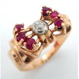 A 14K ROSE GOLD DESIGNER RING WITH CENTRAL DIAMOND FLANKED BY RUBIES . 8.1gms size L