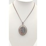 A vintage sterling silver floral motif locket pendant on silver chain. Full Birmingham hallmarks,