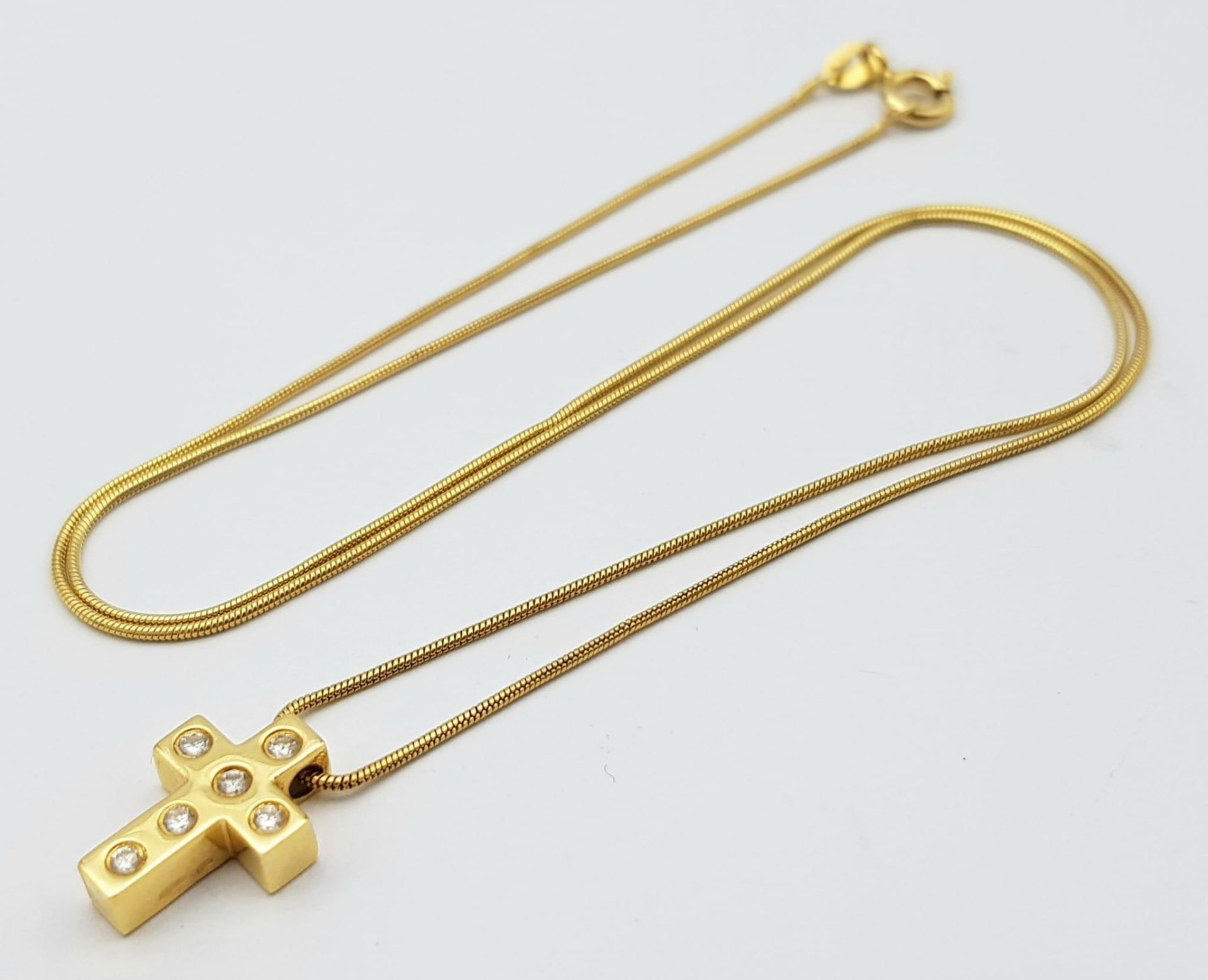 An 18K Yellow Gold and Diamond Cross Pendant on an 18K Yellow Gold Disappearing Necklace.