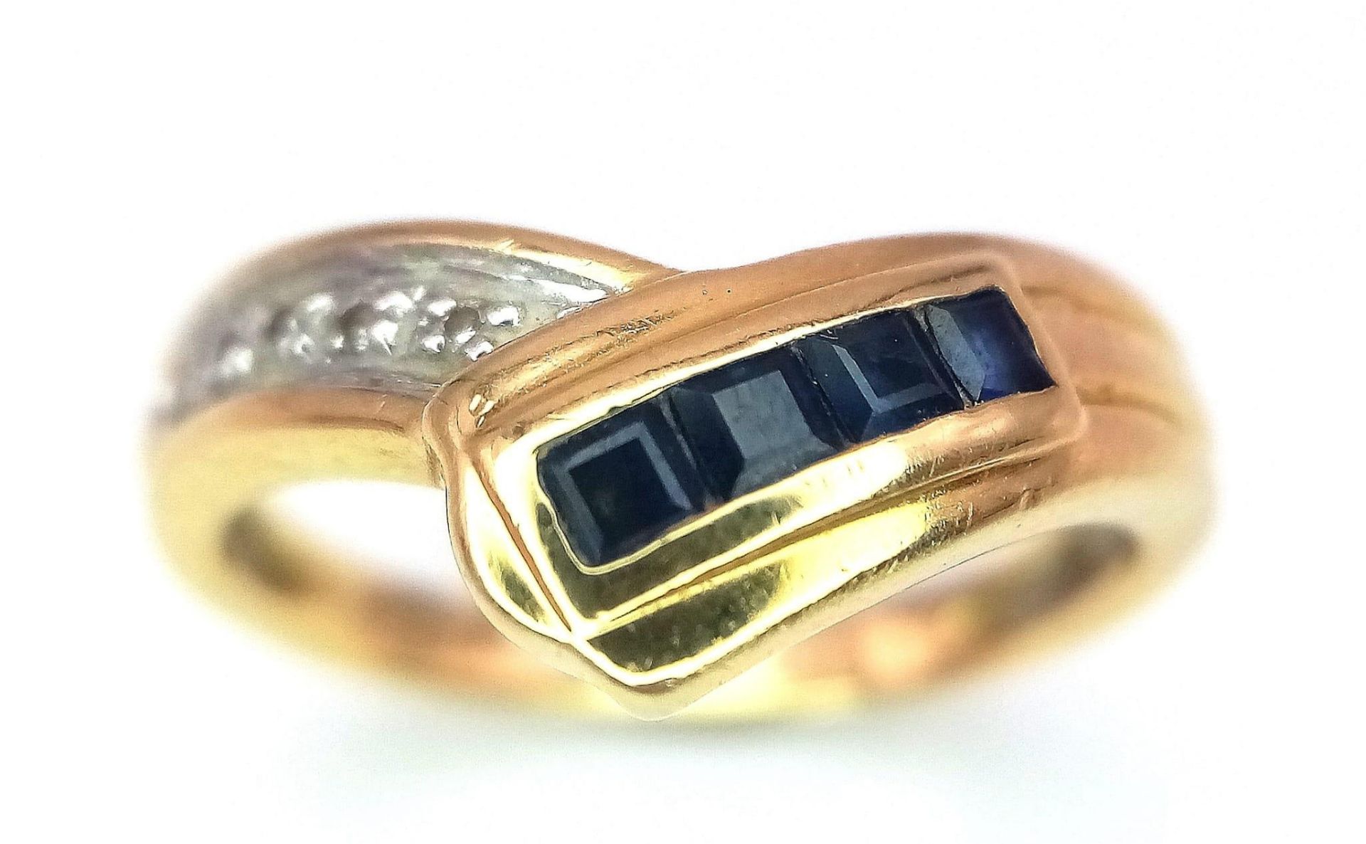 A Stylish 18K Yellow Gold Diamond and Sapphire Crossover Ring. Size L. 3.6g total weight.