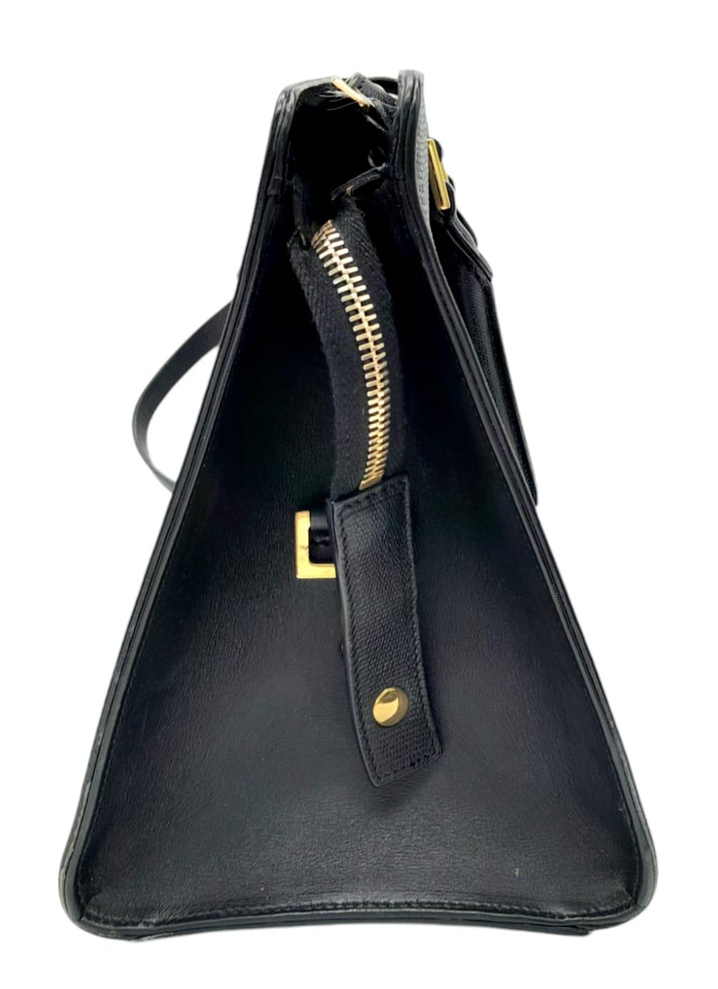 An Yves Saint Laurent Black 'Cabas' Handbag. Leather exterior with gold-toned hardware, two rolled - Image 3 of 8