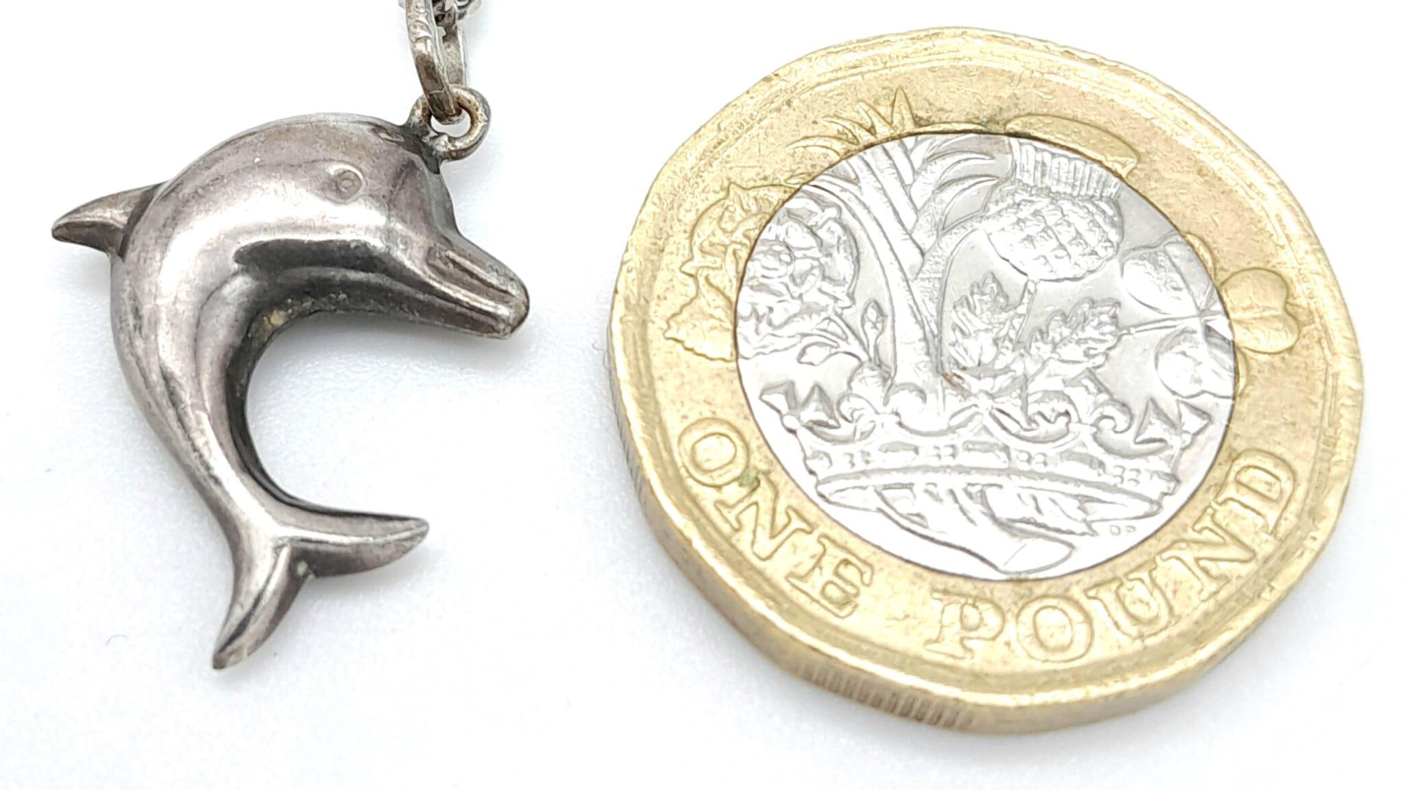 A vintage sterling silver dolphin pendant on silver curb chain. Total weight 4.2G. Total length - Image 5 of 6