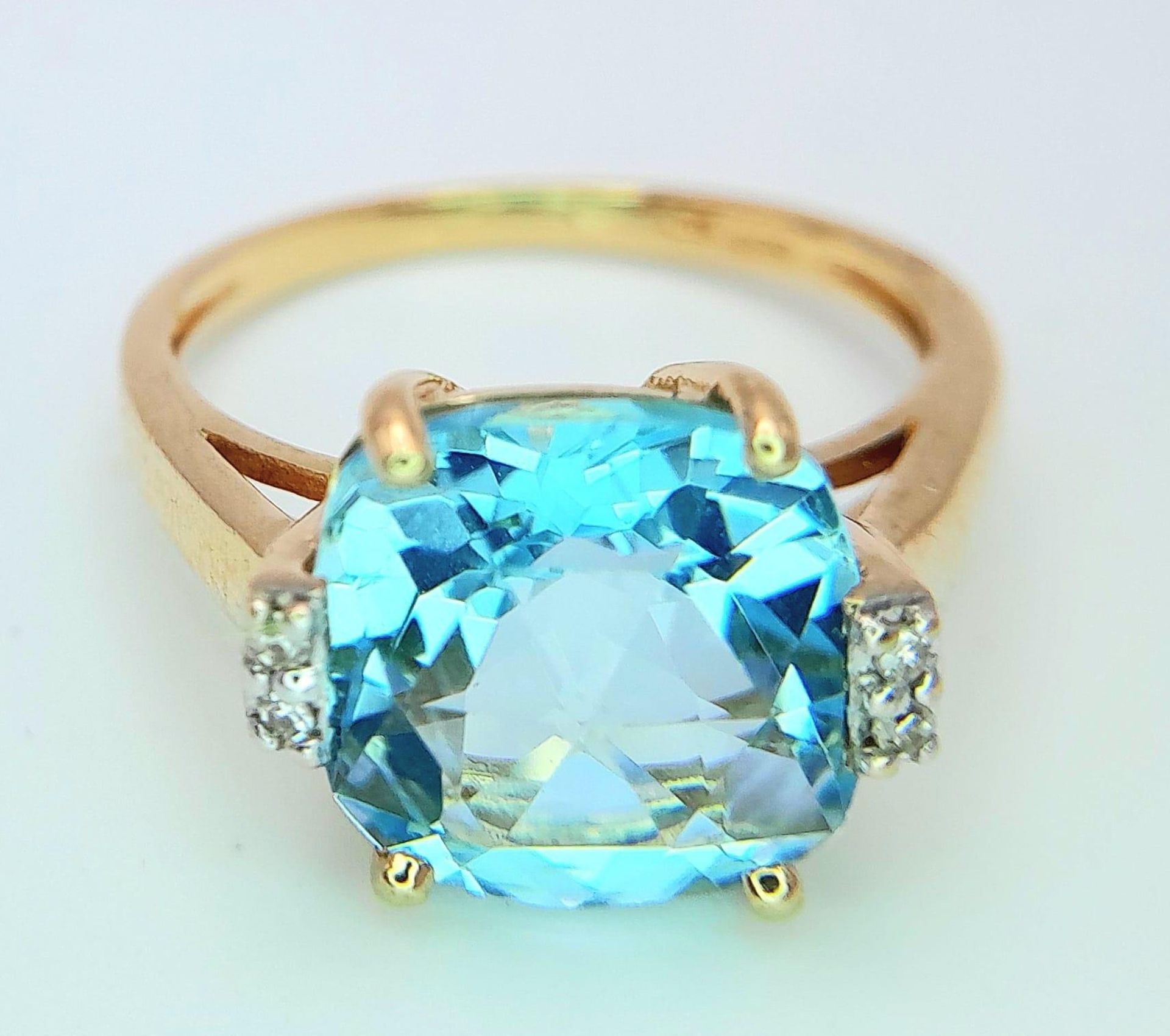 A very attractive 14 K yellow gold ring with a large, cushion cut aquamarine and a pair of