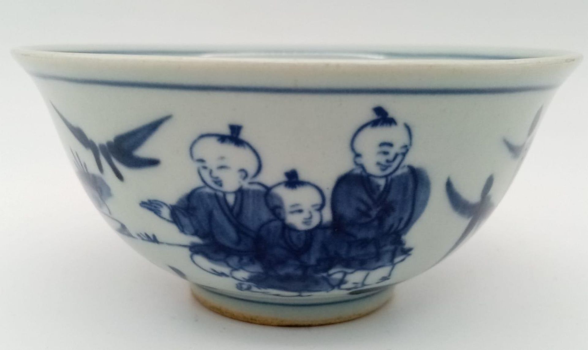 A Chinese blue and white hand painted bowl decorated with children playing with birds. White - Image 2 of 6