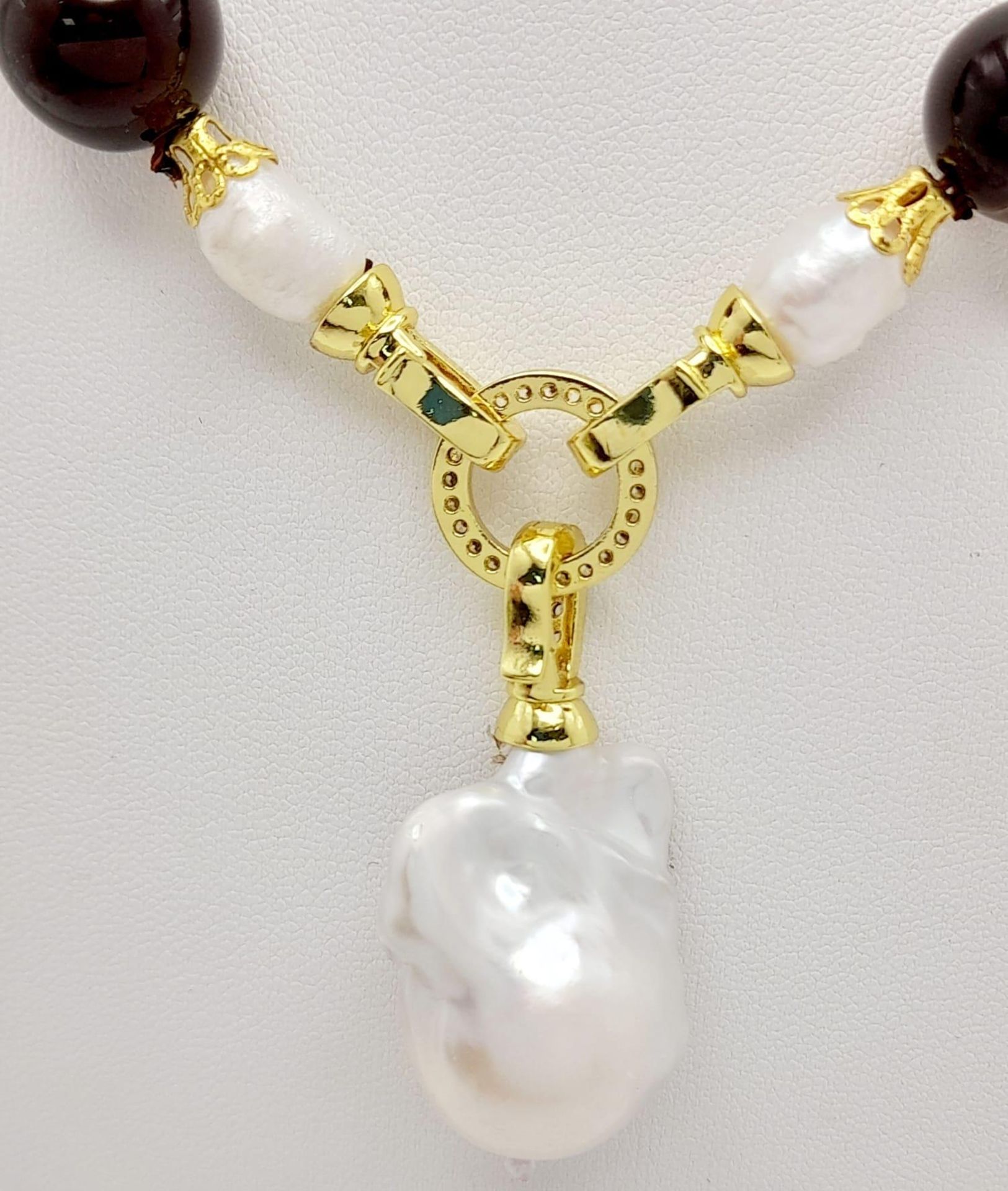 A Striped Agate Beaded Necklace with a Baroque Pearl Hanging Pendant. Gilded clasp. White stone - Image 2 of 3