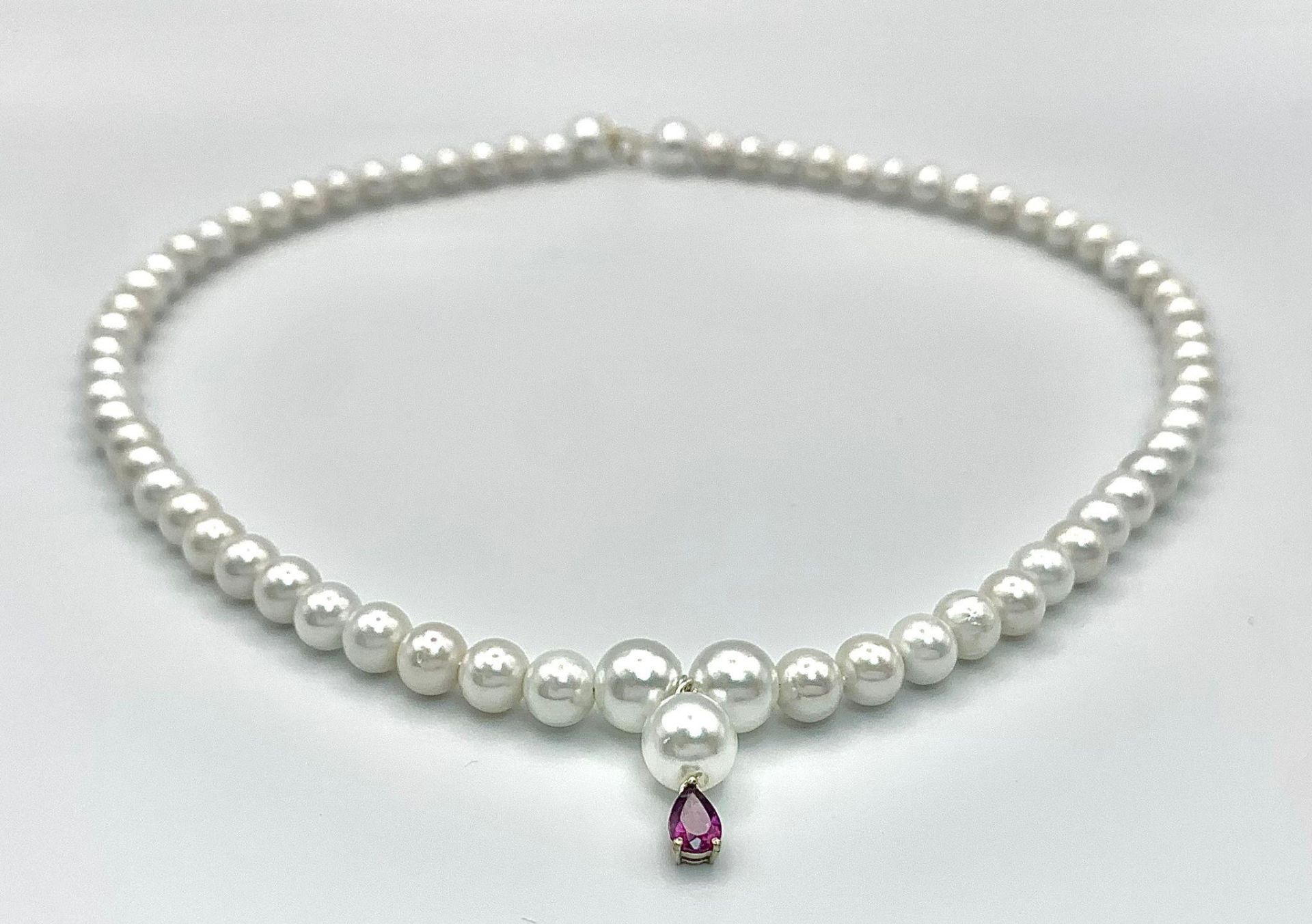 A faux pearl necklace with a 14 K yellow gold clasp and a small amethyst pendant. Length: 43 cm,