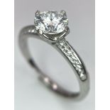 A sterling silver ring with a round cut moissanite (1 carat) an two bands of moissanites on each