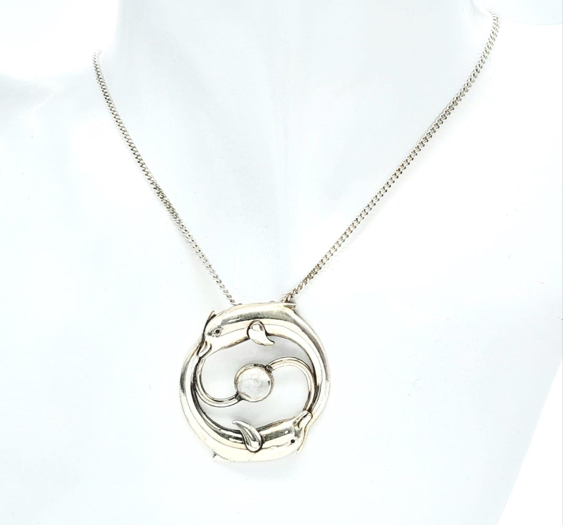 A 985 Silver, Moonstone Set Leaping Dolphin Pendant Necklace. Pendant Measures 3.6cm Length, Set