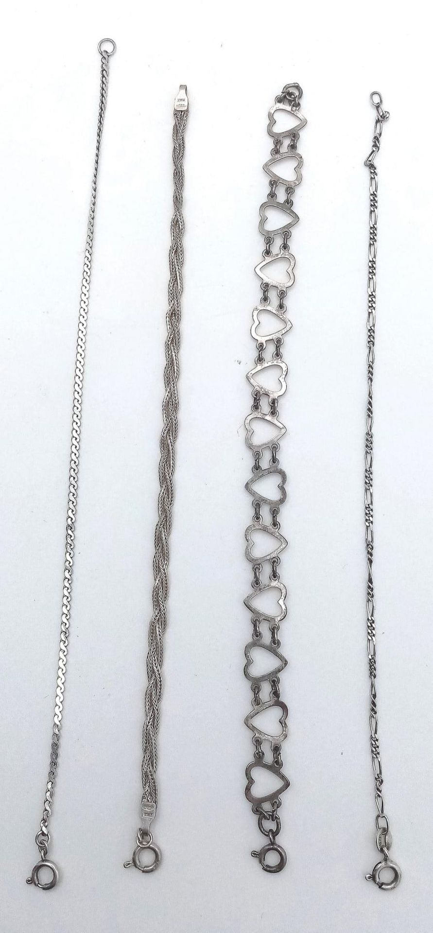 A collection of 4 stylist sterling silver bracelets include a figaro link, twisted, heart link and - Image 4 of 13