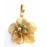 An 18K Yellow Gold Peridot Flower Brooch. Nine peridots amongst golden petals. 5cm. 6.45g total