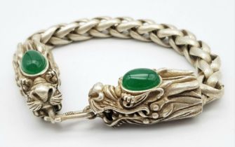 A Tibetan Silver and Green Jade Double Dragon Bracelet. Chinese dragon heads with jade cabochon