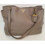 A Prada Grey Leather Shoulder Bag. Textured leather exterior with gold tone hardware. Textile and