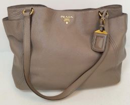 A Prada Grey Leather Shoulder Bag. Textured leather exterior with gold tone hardware. Textile and