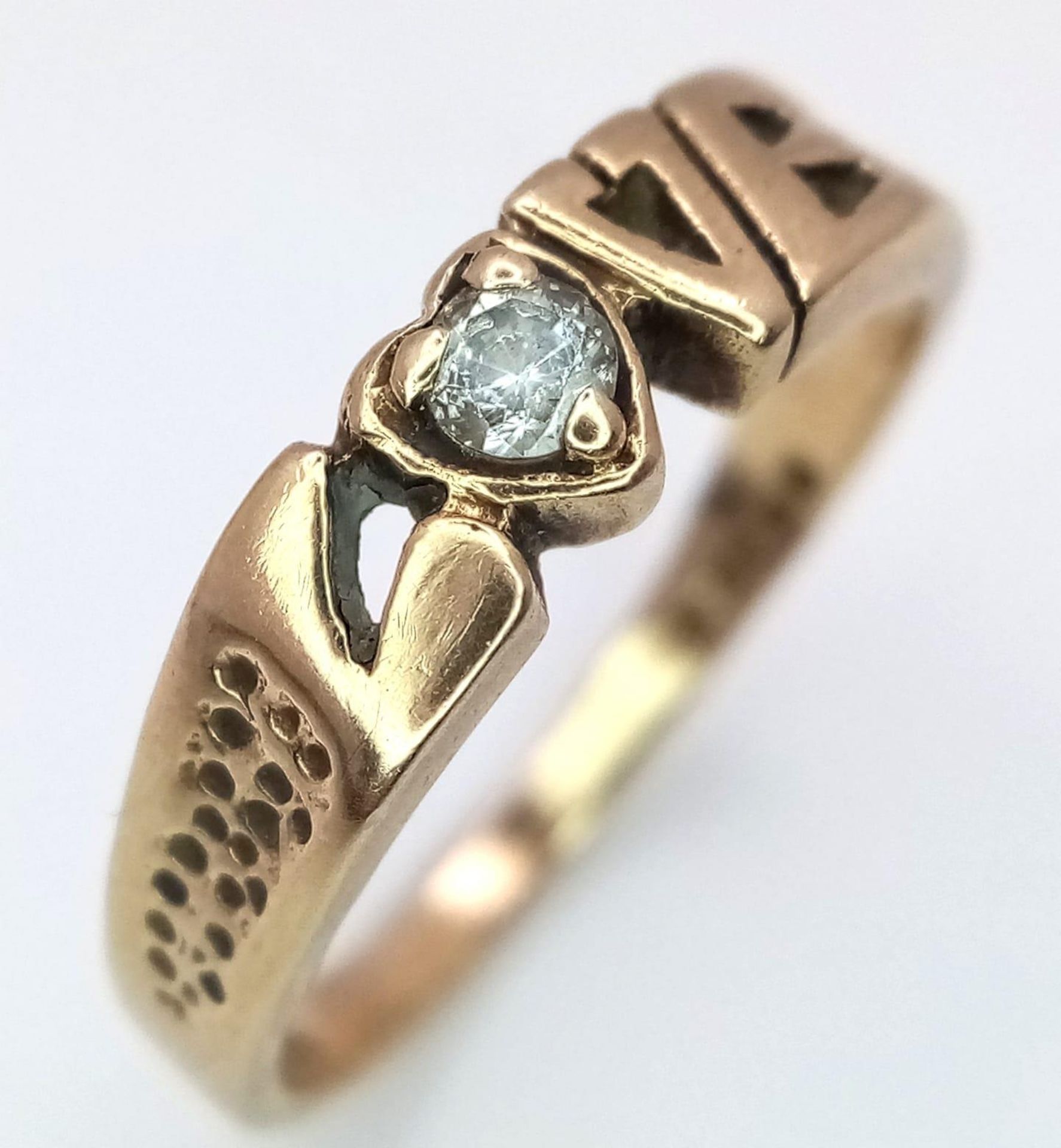 A 9K Yellow Gold 'Love' Ring with White Stone Decoration. Size O/P. 2.52g weight.