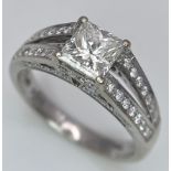 An 18K White Gold Diamond Ring. Central VS2 1ct Princess Cut Near White Diamond with Round Cut