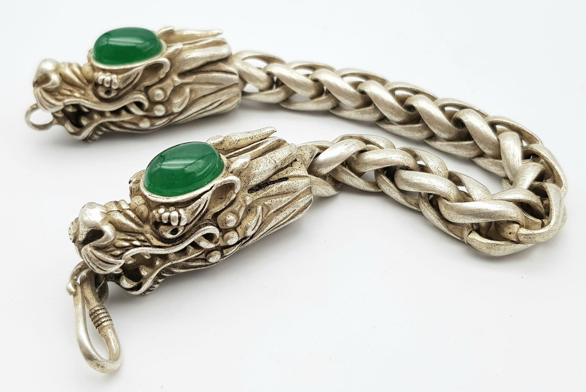 A Tibetan Silver and Green Jade Double Dragon Bracelet. Chinese dragon heads with jade cabochon - Image 4 of 5