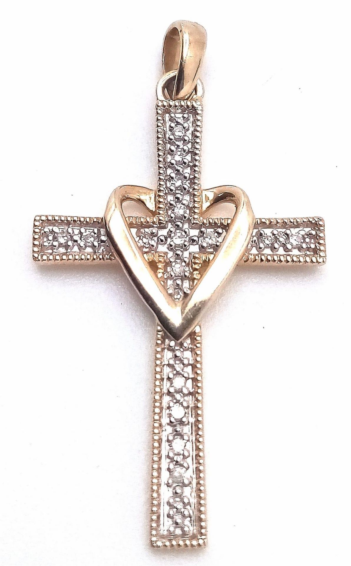 A 9K YELLOW GOLD DIAMOND SET CROSS WITH HEART OVERLAY DESIGN. 0.10CTW. 1.3G.