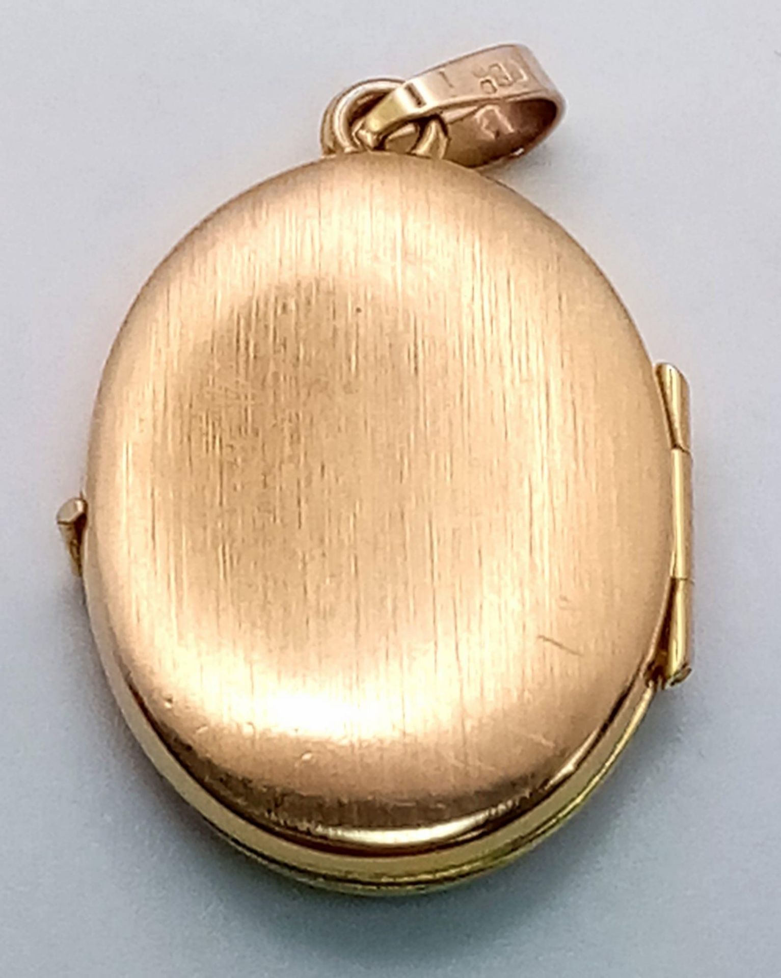 A 9K Yellow Gold Oval Locket Pendant. Decorative white gold floral scene. 3cm. 2.2g weight. - Image 3 of 5