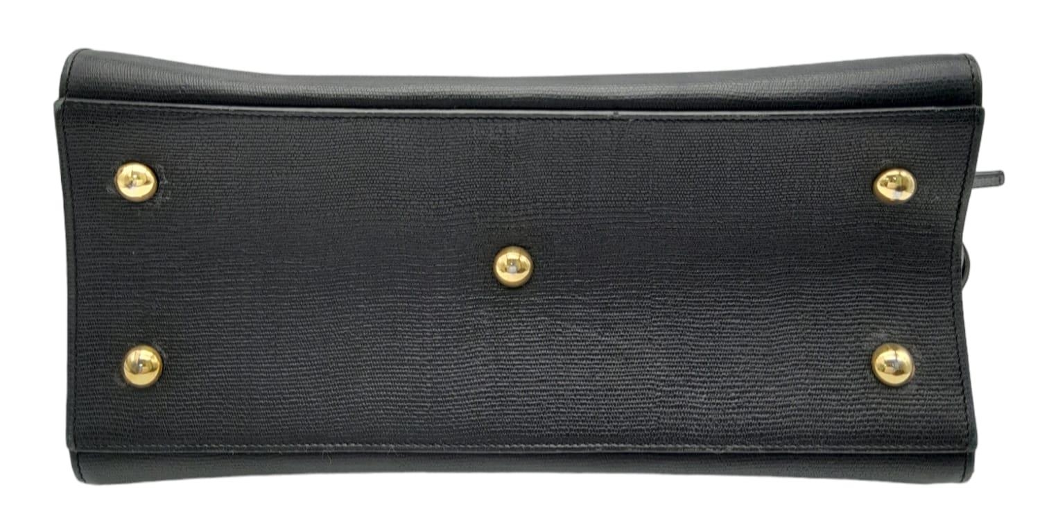 An Yves Saint Laurent Black 'Cabas' Handbag. Leather exterior with gold-toned hardware, two rolled - Image 5 of 8