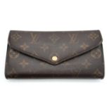 A Louis Vuitton Monogram Wallet. Leather exterior with an open compartment on back and press stud