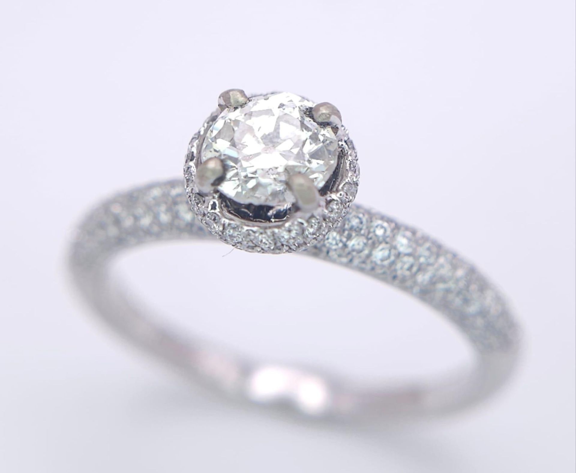 A 14K WHITE GOLD DIAMOND DIAMOND HALO RING WITH FULL SET SHOULDERS AND COLLET. 1.10CT. 2.9G. SIZE - Bild 2 aus 7