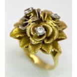 An 18K Yellow Gold and Diamond Floral Design Ring. A rich cluster of golden petals give sanctuary to