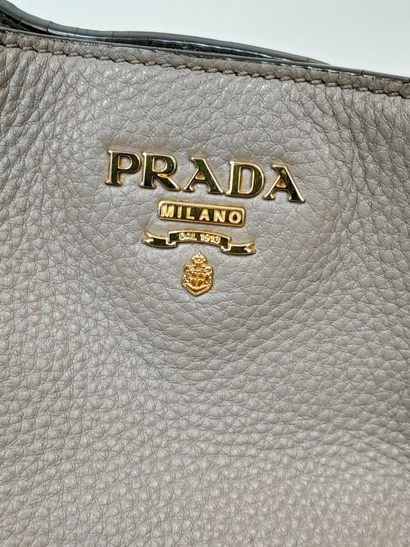 A Prada Grey Leather Shoulder Bag. Textured leather exterior with gold tone hardware. Textile and - Image 5 of 9