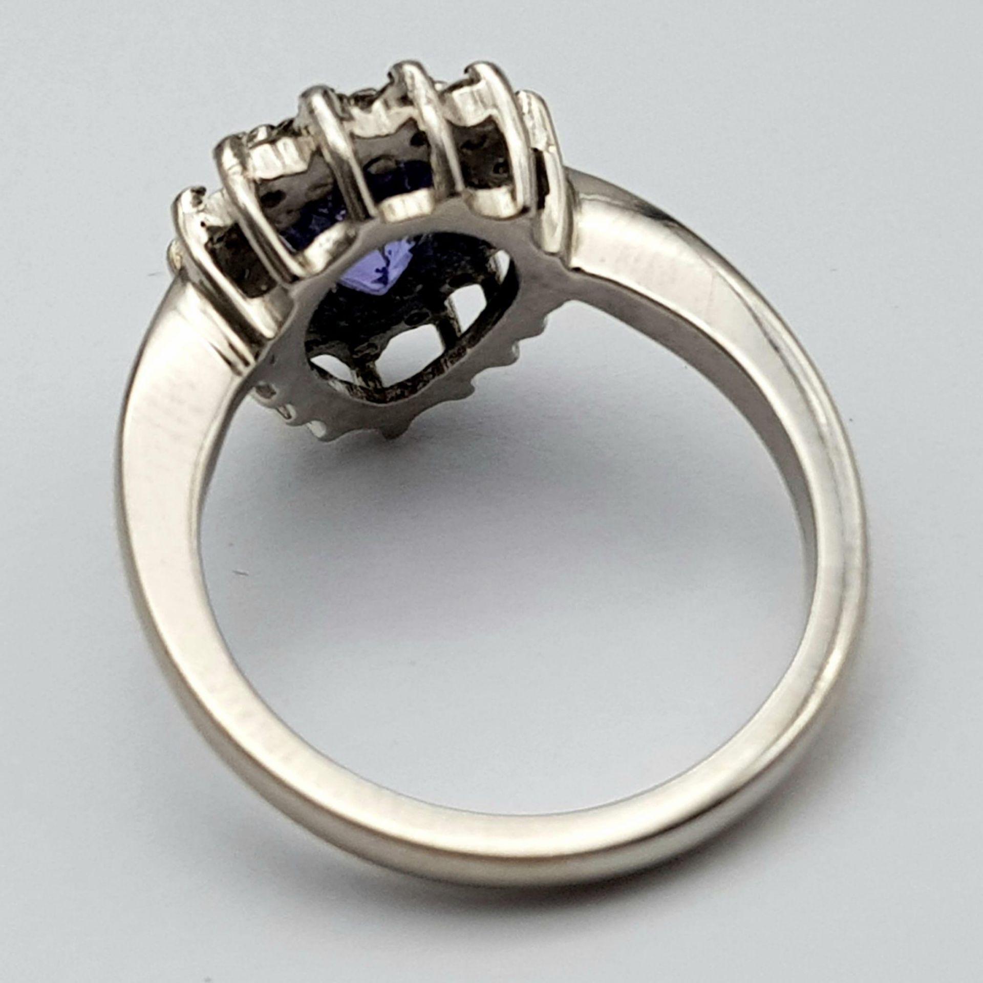An 18 K white gold ring with a pear cut tanzanite (1.71 carats) surrounded by a halo of diamonds, - Image 6 of 12
