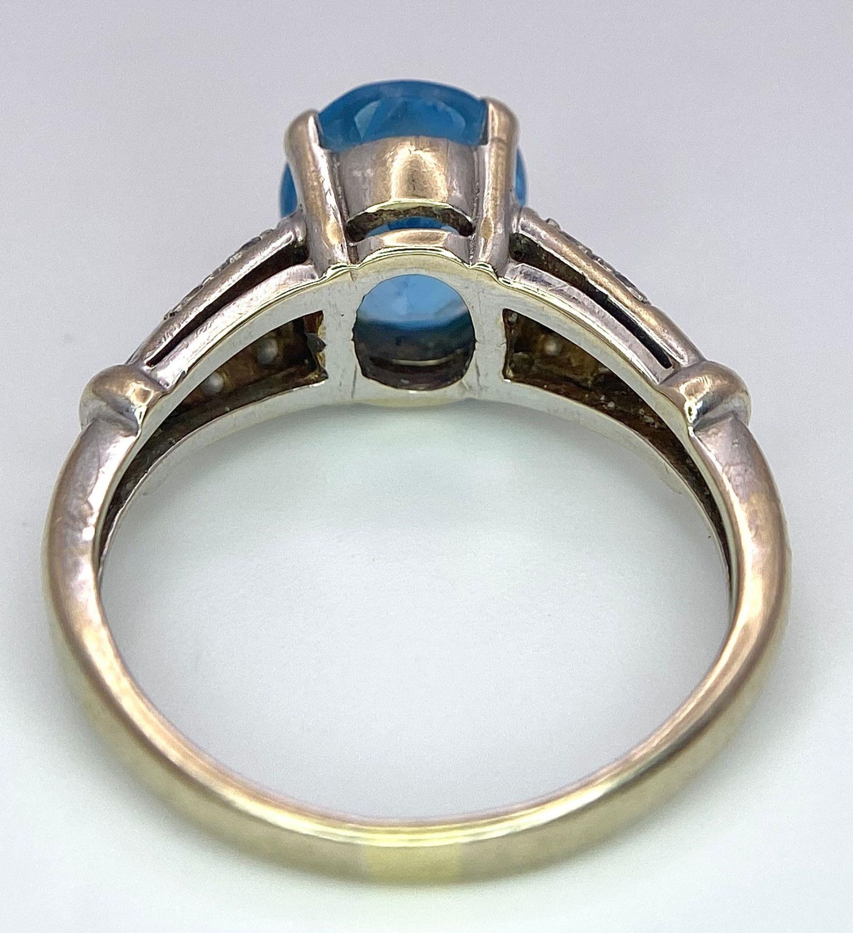 A vintage, 9 K white gold ring with a large, oval cut, vivid blue aquamarine and three bands of - Image 5 of 5