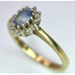 A 9K Yellow Gold Aquamarine and Diamond Ring. Central aquamarine with a 0.10ctw diamond surround.