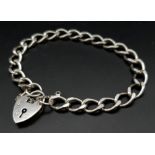 A vintage sterling silver curb bracelet with heart locket. Full London hallmarks, 1975. Total weight