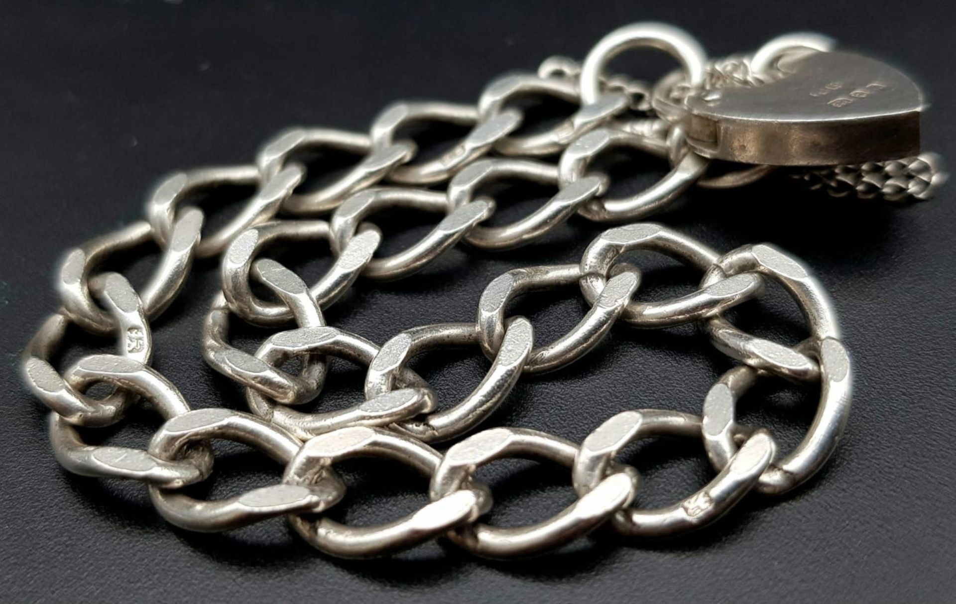 A vintage sterling silver curb bracelet with heart locket. Full London hallmarks, 1975. Total weight - Image 7 of 10